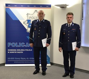 5. awansowani policjanci stoją przy banerze sądeckiej Policji