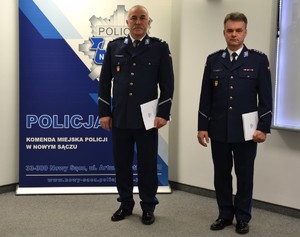 5. awansowani policjanci stoją przy banerze sądeckiej Policji — kopia