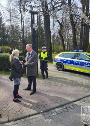 Zastępca Dyrektora MORD-u rozmawiający z pieszą, obok policjantka i oznakowany radiowóz