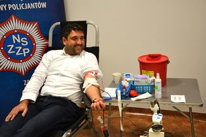 nieumundurowany funkcjonariusz podczas oddawania krwi