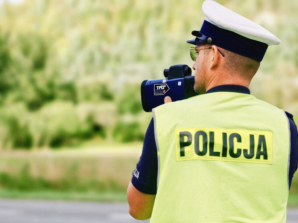 policjant z laserowym miernikiem prędkości