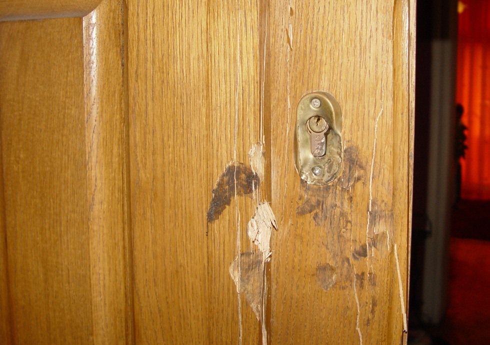 fragment drzwi uszkodzonych przez włamywacza