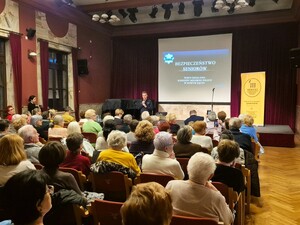 2. Zastępca KMP w N. Sączu rozpoczyna prelekcję, w sali seniorzy przybyli na spotkanie