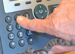 męska dłoń wybiera na klawiaturze numer telefonu