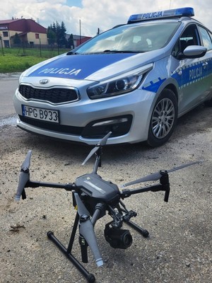 dron, w tle oznakowany radiowóz