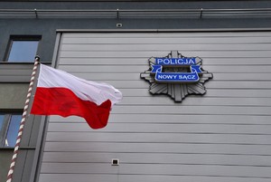 flaga, obok logo KMP na budynku komendy