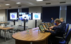 komendanci i goście na sali, w tle ekrany