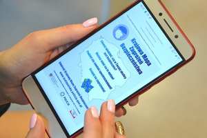 Plakat KMZB na telefonie komórkowym