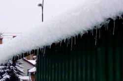 śnieg i sople lodu zwisające z zadaszenia