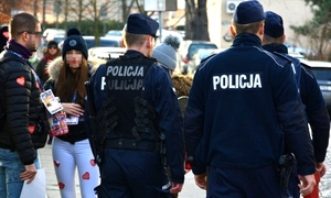 patrol policji, obok kwestujący wolontariusze WOŚP