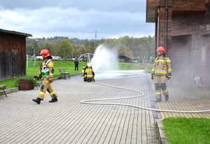 8. strażacy rozwijają węża strażackiego