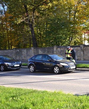 12. przedstawiciel MORD przekazuje apteczkę kierowcy, obok policjant wręczający element odblaskowy