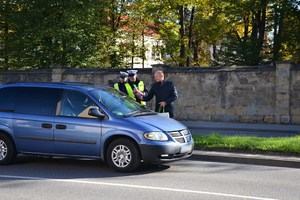 14. policjanci z Zastępcą Dyrektora MORD przekazują kierowcy apteczkę i odblaski