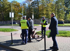 16. policjanci i przedstawiciel MORD przekazują odblaski rowerzyście