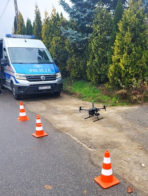 dron wylądował przed radiowozem, miejsce ogrodzone jest pachołkami