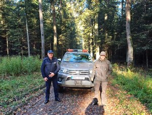 policjant i strażnik leśny przy pojeździe Straży Leśnej