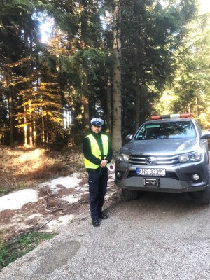 policjant ruchu drogowego, obok pojazd Straży Leśnej