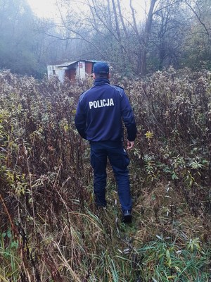 policjant prewencji idący w kierunku pustostanu