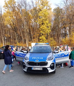 Grupa dzieci ogląda wnętrze radiowozu policyjnego