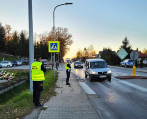 policjantka wspólnie z strażnikiem miejskim dbają o bezpieczeństwo w pobliżu przejścia dla pieszych i cmentarza