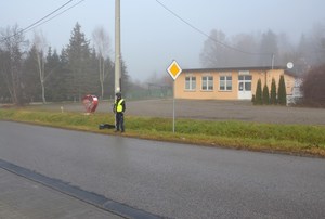 2. umundurowany policjant stoi przy drodze