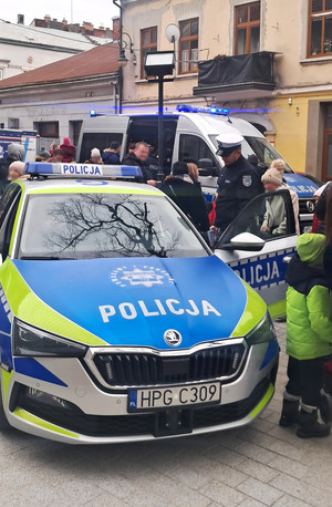 policjant pokazuje radiowóz najmłodszym