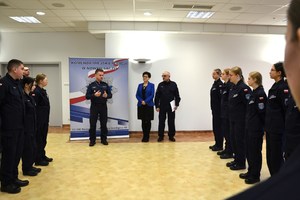 komendant Zacher przemawia do uczniów, obok dyrektor szkoły i nauczyciel