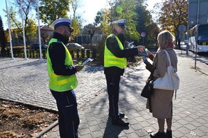 funkcjonariusz przekazuje kobiecie element odblaskowy