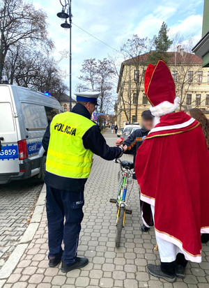 policjant wręcza element odblaskowy rowerzyście