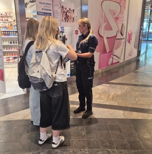 policjantka wręcza ulotki nastolatkom
