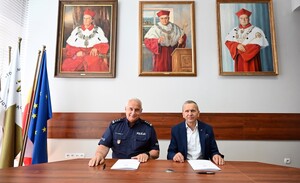 komendant i rektor siedzą przy stole, przed nimi dokumenty i pióra2