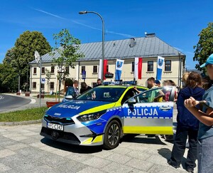 młodzież ogląda policyjny radiowóz