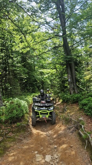 policyjny quad wjeżdża pod górę stroną drogą