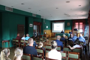 1. zastępca naczelnika Wydziału Prewencji przy mównicy, w sali organizatorzy podczas debaty