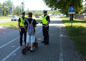 policjanci rozmawiają z użytkownikiem hulajnogi elektrycznej — kopia
