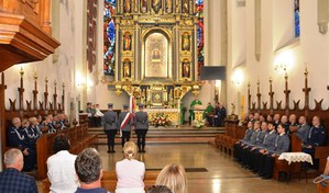 ołtarz, w ławach policjanci i osoby uczestniczące we mszy świętej