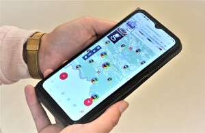 telefon komórkowy w dłoniach kobiety, na wyświetlaczu strona KMZB