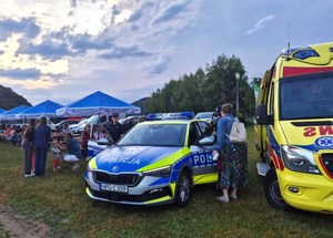 policjantki przy radiowozie, jedna z nich rozmawia z kobietą