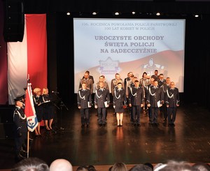 19. scena, awansowani policjanci, obok poczet sztandarowy