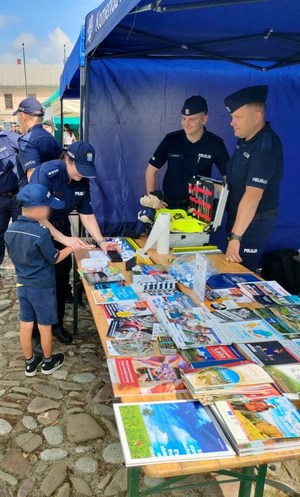 chłopiec odbija swoje linie papilarne na pamiątkowym dyplomie