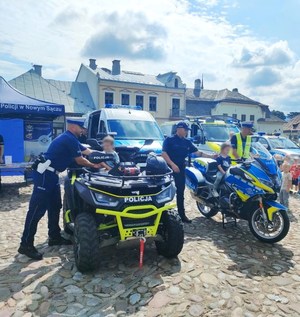 dzieci siedzą na policyjnym quadzie i motocyklu