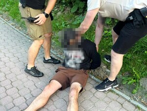 dwóch nieumundurowanych policjantów zatrzymuje podejrzewanego mężczyznę