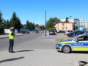 policjant z laserowym  miernikiem prędkości przy jednej z ulic Nowego Sącza, obok oznakowany radiowóz