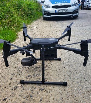 dron, na drugim planie policyjny radiowóz