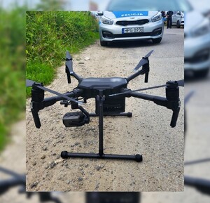 dron, na drugim planie policyjny radiowóz