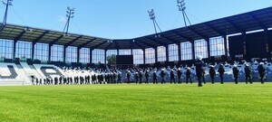 funkcjonariusze stoją w rzędzie przed trybunami