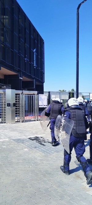 policjanci prewencji biegną w kierunku stadionu