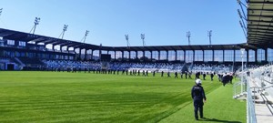 policjanci przemieszczają się po murawie stadionu