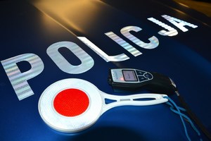 alkomat i tarcza do zatrzymywania pojazdów położone na masce radiowozu, obok widoczny napis Policja