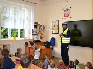 funkcjonariusz ruchu drogowego podczas prelekcji w sali lekcyjnej